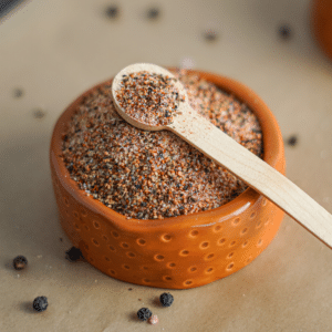 homemade steak seasoning: chili steak rub in a small clay bowl with a wooden spoon