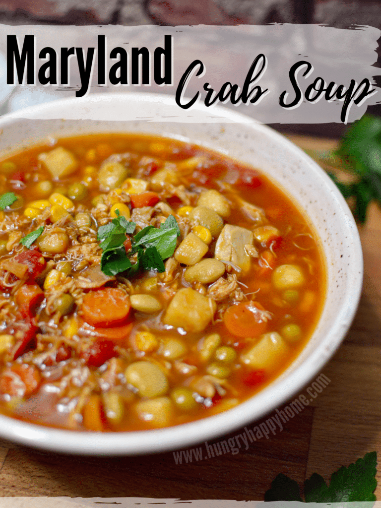 Image showing a ceramic bowl full of maryland crab soup set on a wooden butcher block.