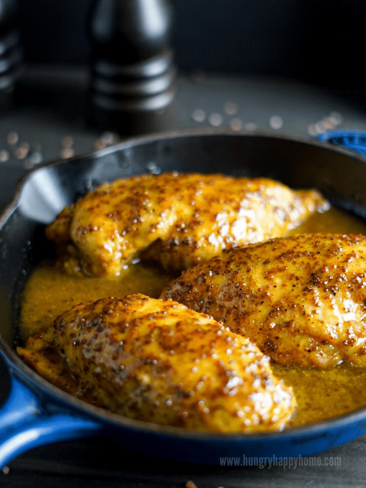 Curry Maple Mustard Chicken on a blue ceramic plate with rice and steamed broccoli.