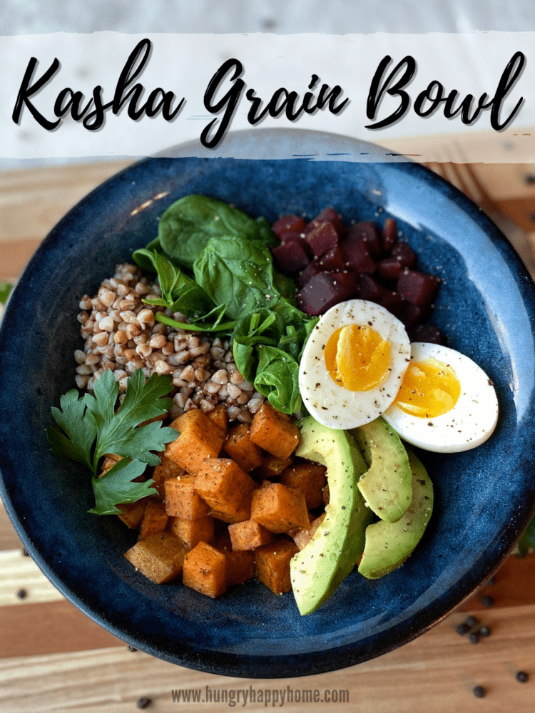 Kasha, steamed vegetables, baked sweet potato cubes and a hardboiled egg in a blue ceramic bowl. Sprinkled with salt and pepper.