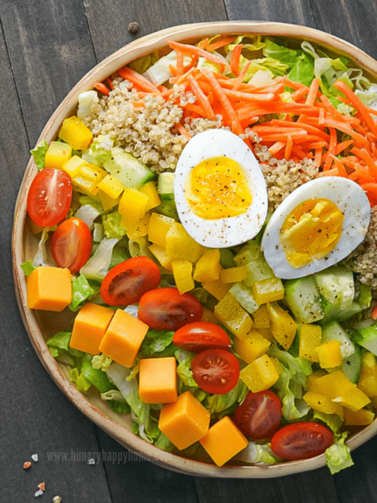 Quinoa Chef Salad in ceramic dish on wooden table.