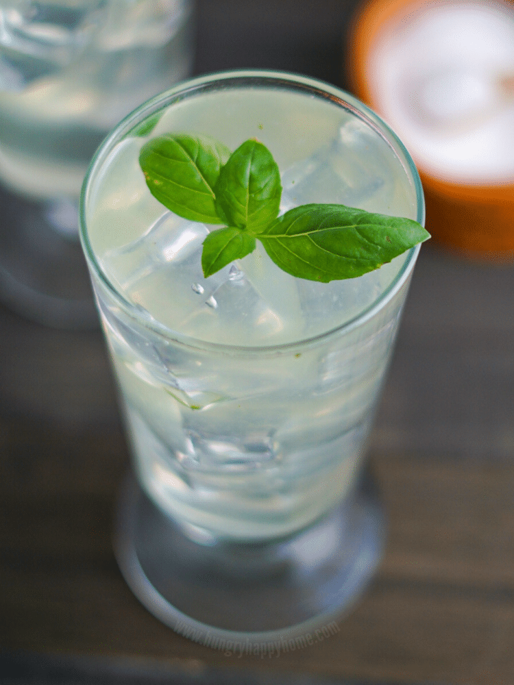 Fresh Sweet Basil Lemonade in a tall glass and garnished with fresh sweet basil leaves.