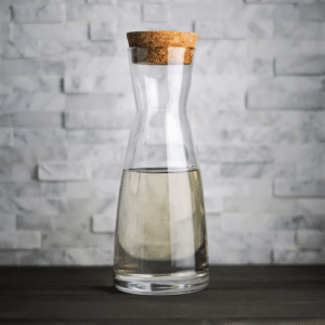 Homemade Simple Syrup in a clear glass bottle with a cork lid.