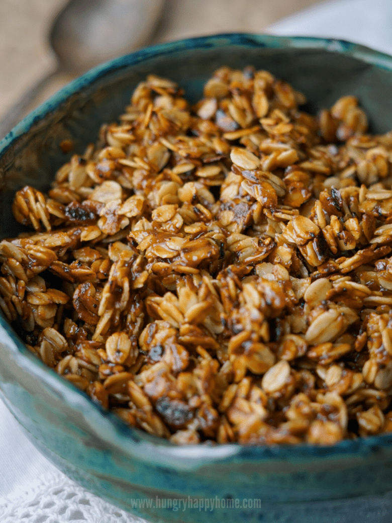 Close up image of stove-top granola in a handmade green ceramic bowl.