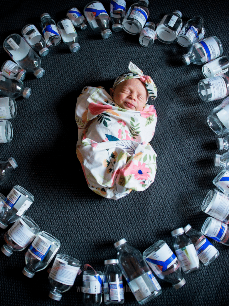 Image of baby surrounded by medicine bottles.