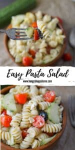 Wooden bowl with pasta salad in it that has cucumbers, tomatoes, olives and artichokes.