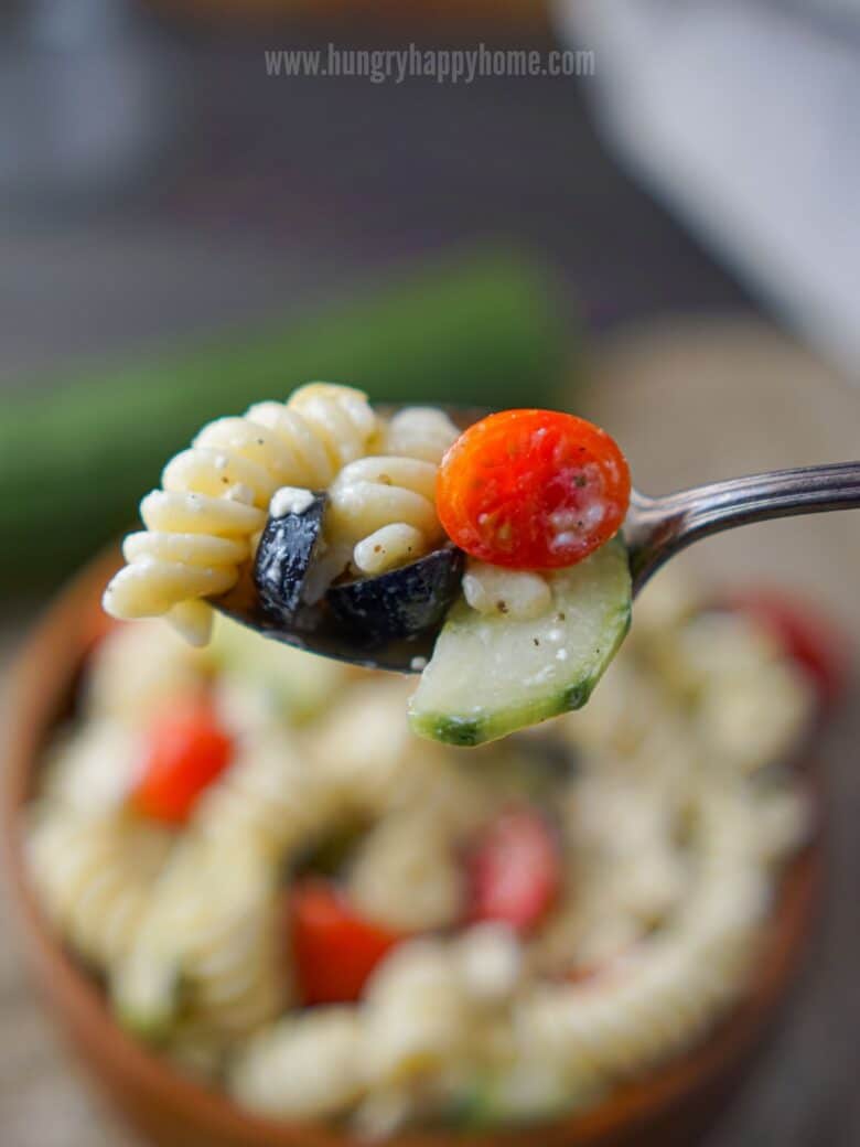 Antique silver spoon filled with pasta salad.